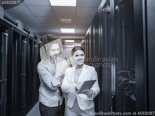 Image of engineer showing working data center server room to female chief