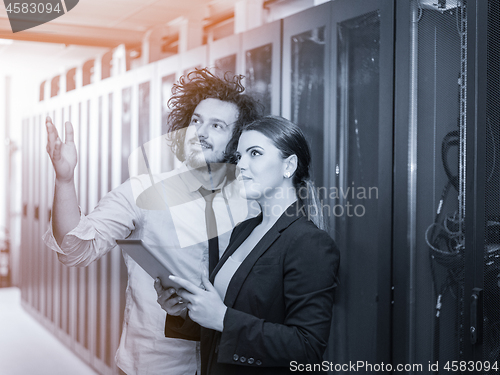 Image of engineer showing working data center server room to female chief