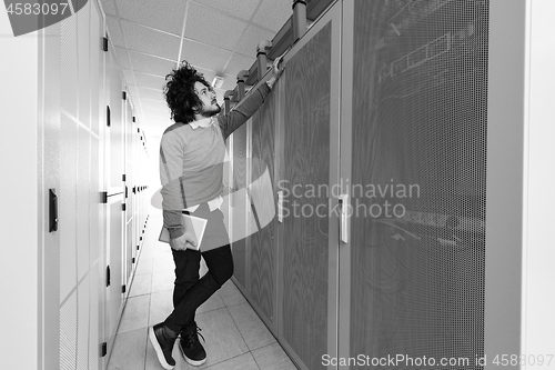 Image of IT engineer working on a tablet computer in server room