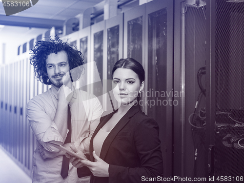 Image of engineer showing working data center server room to female chief