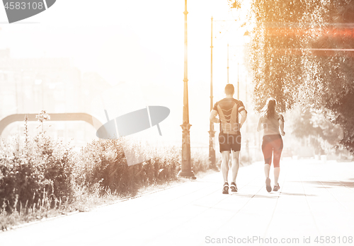 Image of young couple jogging  in the city