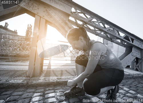 Image of woman tying running shoes laces