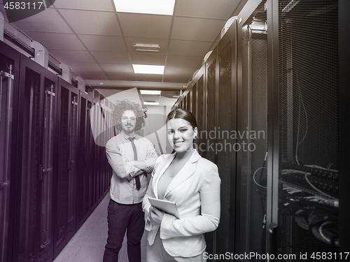 Image of engineer showing working data center server room to female chief