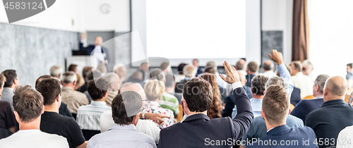 Image of I have a question. Group of business people sitting in conference hall. Businessman raising his arm. Conference and Presentation. Business and Entrepreneurship