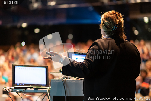 Image of Public speaker giving talk at Business Event.