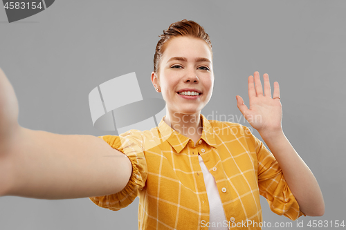 Image of smiling red haired teenage girl taking selfie