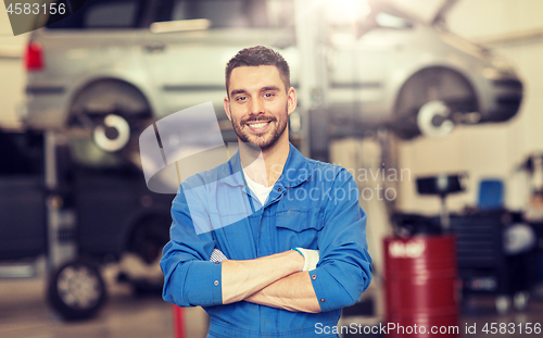 Image of happy auto mechanic man or smith at car workshop