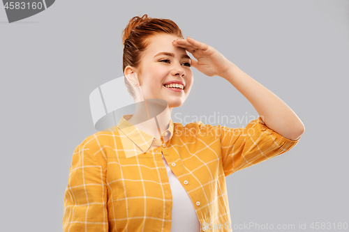 Image of smiling red haired teenage girl looking far away