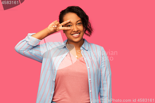 Image of happy african american woman showing peace