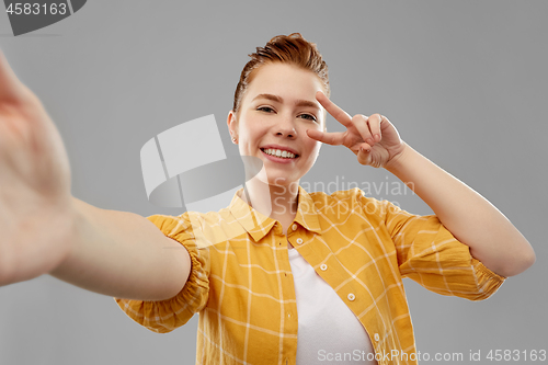 Image of redhead teenage girl taking selfie making peace