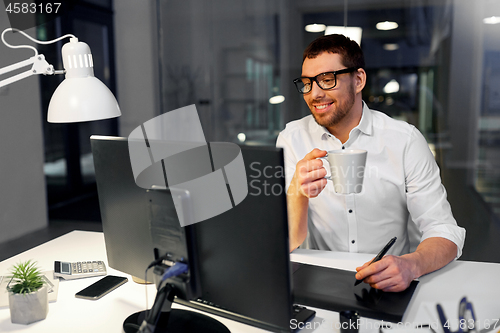 Image of designer with pen tablet drinking coffee at office