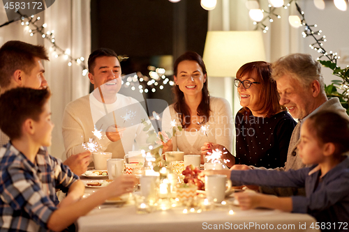 Image of family with sparklers having tea party at home
