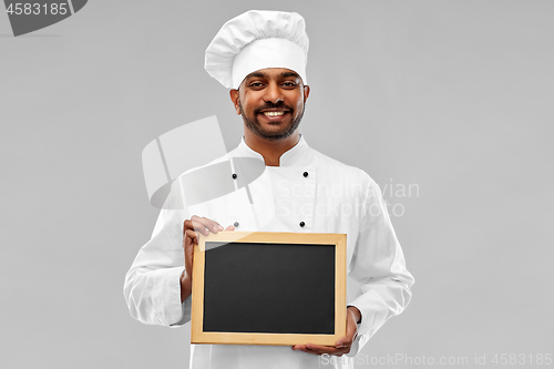 Image of happy male indian chef in toque with chalkboard