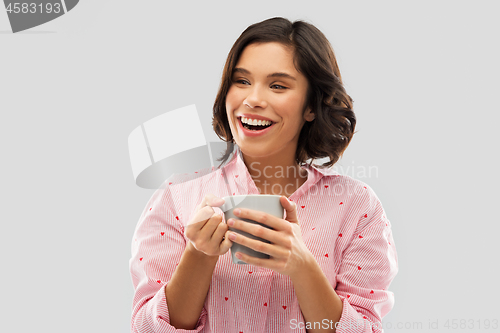 Image of happy young woman in pajama with mug of coffee