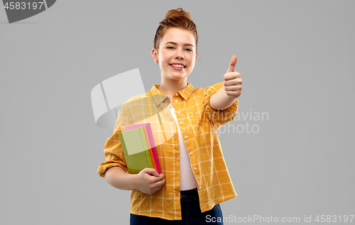 Image of teenage student girl with books showing thumbs up