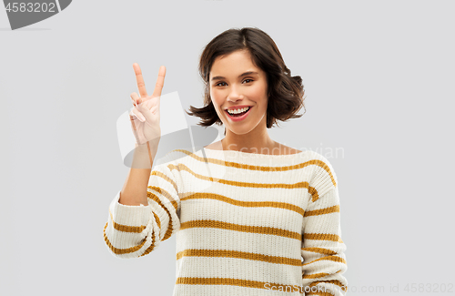 Image of happy smiling woman showing peace or two fingers