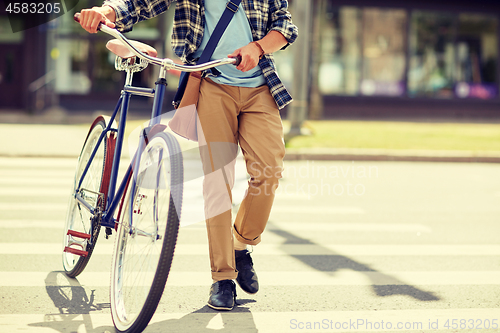 Image of young man with fixed gear bicycle on crosswalk