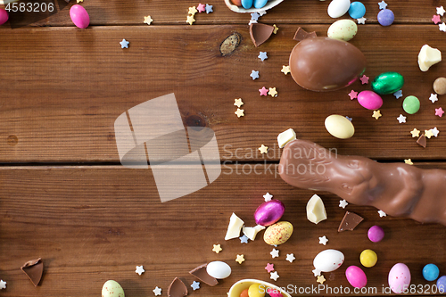 Image of chocolate eggs, easter bunny and candies on wood