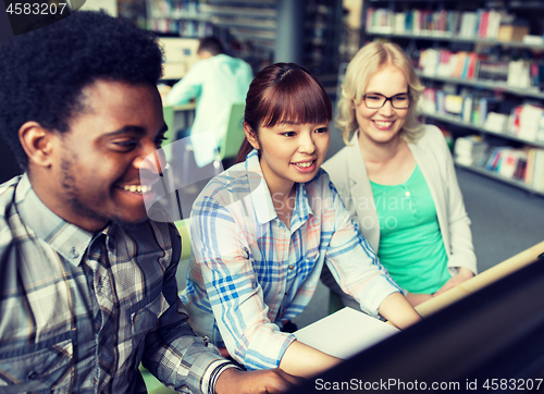 Image of international students with computers at library