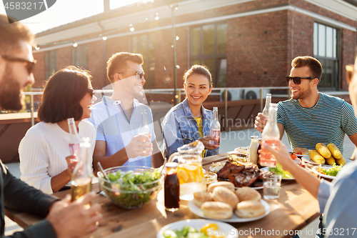 Image of happy friends with drinks or bbq party on rooftop