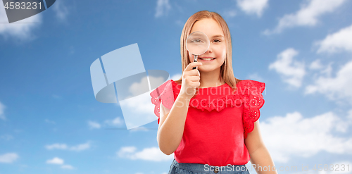 Image of happy girl looking through magnifying glass