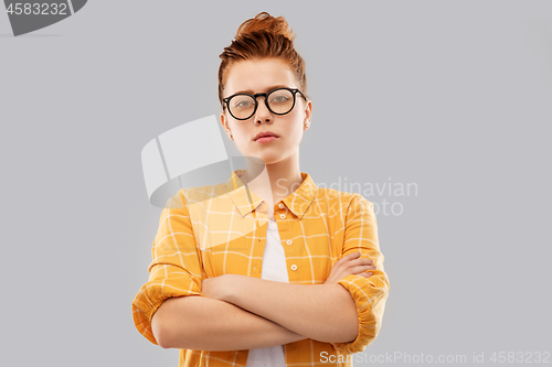 Image of redhead student girl in glasses with crossed arms