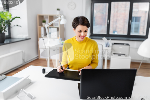 Image of designer with computer and pen tablet at office