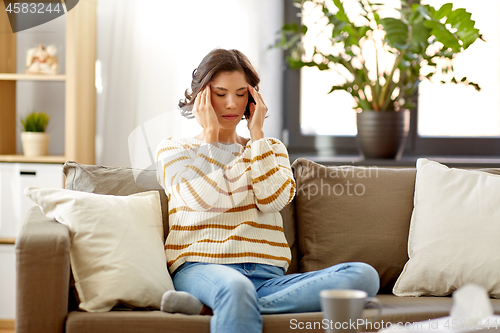 Image of sad sick woman in scarf at home