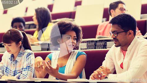 Image of group of students with notebooks in lecture hall