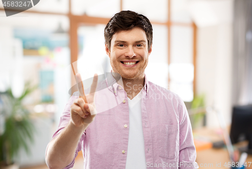 Image of man showing two fingers or peace over office room