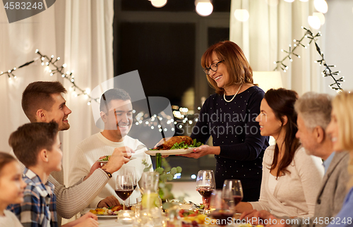 Image of happy family having dinner party at home