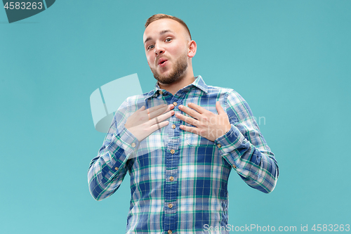 Image of The happy business man standing and smiling against blue background.