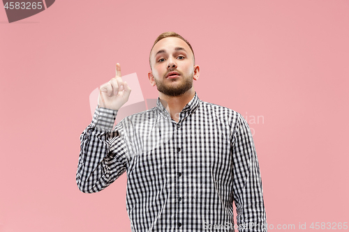 Image of The happy business man standing and smiling against pink background.