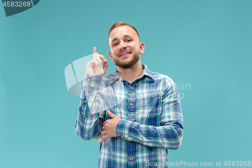 Image of The happy business man standing and smiling against blue background.