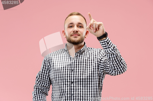 Image of The happy business man standing and smiling against pink background.