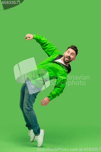 Image of handsome bearded young man looking at camera isolated on green
