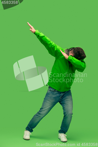 Image of handsome bearded young man looking at camera isolated on green