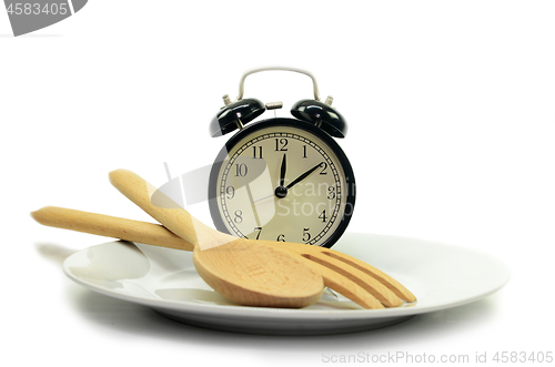 Image of Alarm clock with fork and knife on the plate