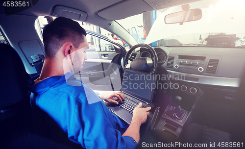 Image of mechanic man with laptop making car diagnostic