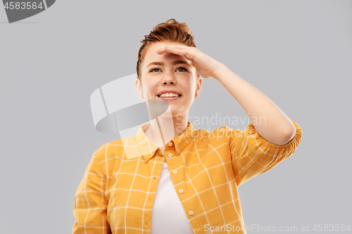 Image of smiling red haired teenage girl looking far away