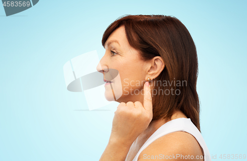 Image of senior woman pointing to her golden earring