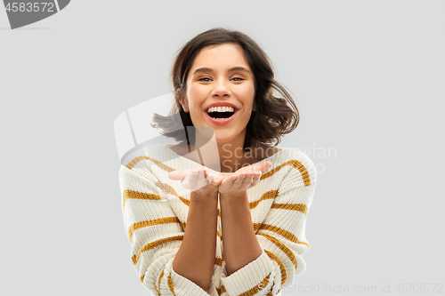 Image of smiling young woman holding empty palms