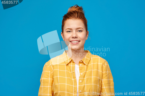 Image of smiling red haired teenage girl in checkered shirt
