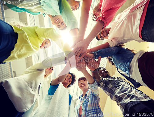 Image of group of international students with hands on top