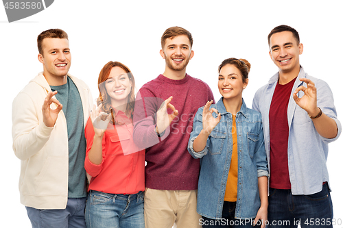 Image of group of smiling friends showing ok hands sign