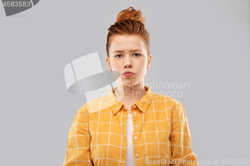 Image of sad red haired teenage girl in shirt pouting