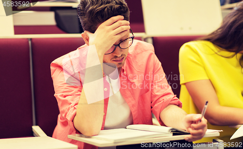 Image of group of students with notebooks in lecture hall