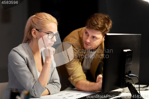 Image of business team with computer at night office