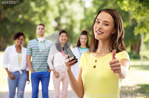 Image of teenage girl with smartphone showing thumbs up