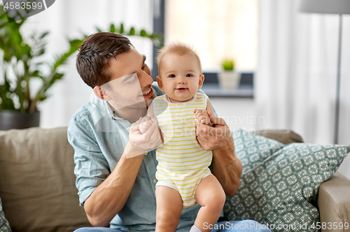 Image of father with little baby daughter at home